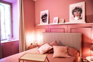 a bedroom with a bed with pink walls at Telesio Suite in Rome +32 photos