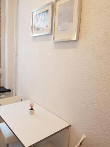 a room with a white table and two pictures on the wall at Appartement "Hope" in Greiz