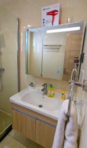 a bathroom sink with a shower and a mirror at Urban Haven 3BR Apartment in Nairobi