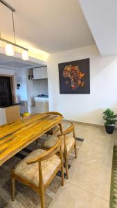 a dining room with a wooden table and benches at Urban Haven 3BR Apartment in Nairobi