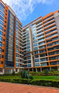 a large apartment building with orange at Urban Haven 3BR Apartment in Nairobi