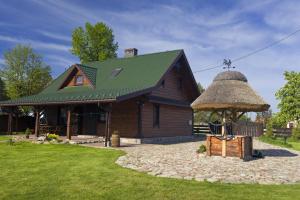 a large wooden house with a thatched roof at Dom pod Lipą in Jaminy