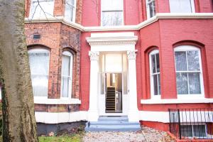 une maison en briques rouges avec une porte d'entrée blanche dans l'établissement Chill Nexus Oasis, à Liverpool