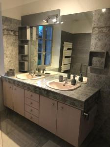 ein Badezimmer mit zwei Waschbecken und einem großen Spiegel in der Unterkunft Villa Evalou de 240 m². in Trévignin