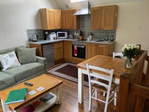 a kitchen with a couch and a table in a living room at Stable Cottage, Bishops Castle in Bishops Castle