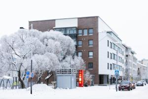 a snow covered street in front of a building at Koda Apartment - Balcony - Great design and location in Rovaniemi