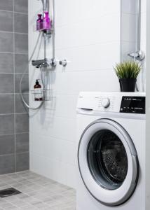 a washing machine in a bathroom next to a wall at Koda Apartment - Balcony - Great design and location in Rovaniemi