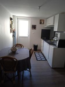 a kitchen with a table and chairs and a kitchen with a table and a kitchen at Maison pour 2 à 4 personnes in Brassac-les-Mines