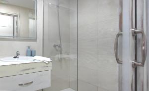 Un baño con ducha de cristal y lavabo. en Alojamientos Rurales Las Candelas, en Santa Marta de Magasca