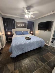 Blue Shark G9 - Midtown 1BR King Suite في هيوستن: غرفة نوم بسرير ومروحة سقف