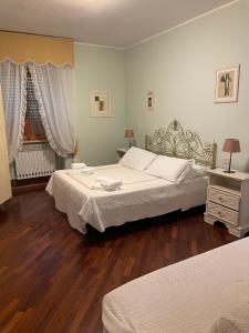 a bedroom with two beds and a wooden floor at AL MANDORLO Casa Vacanze in Viterbo