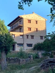 un grand bâtiment en briques au sommet d'une colline dans l'établissement Apartamentos Rurales Fuente del Peral, à Alobras