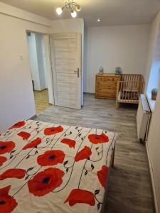een slaapkamer met een bed met rode bloemen erop bij Przestronny apartament +siłownia in Bytom