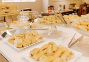 a buffet with plates of food on a table at Firenze Hotel Votuporanga - Próximo ao Assary clube de Campo e o Centro de lazer do trabalhador in Votuporanga