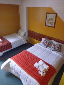 Habitación de hotel con 2 camas y toallas. en Huaraz Center Hostal, en Huaraz