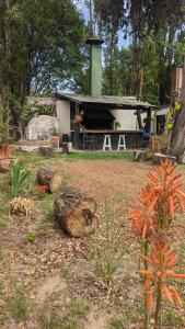 un jardín con troncos y una casa de fondo en Posada Pueyrredón en Luján de Cuyo