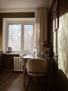 a dining room table with chairs and a window at Квартира в тихом районе правого берега Астаны in Astana
