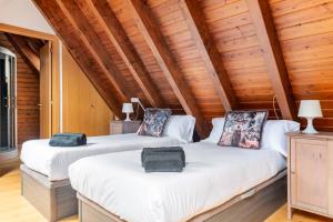 two beds in a room with wooden ceilings at Refugio en las Cumbres in Las Bordas