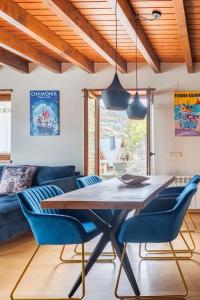 a dining room with a wooden table and blue chairs at Refugio en las Cumbres in Las Bordas