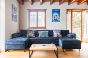 a living room with a blue couch and a table at Refugio en las Cumbres in Las Bordas