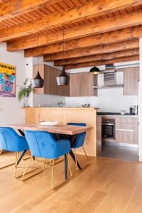 cocina con mesa de madera y sillas azules en Refugio en las Cumbres, en Les Bordes