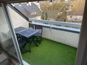 a table and chairs on a balcony with green grass at Appartement Duplex, Résidence Victoria, à 2min de la Grande Plage in Quiberon