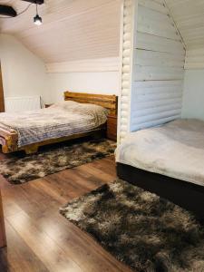 twee bedden in een kamer met houten vloeren bij River House in Jaremtsje