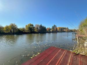 - une vue sur une rivière avec un quai en bois dans l'établissement Relax & Fishing, à Békésszentandrás