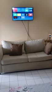 ein Wohnzimmer mit einem Sofa und einem TV an der Wand in der Unterkunft Ocean View Montego Bay Apartment in Montego Bay