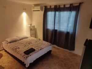 1 dormitorio con cama y ventana en Casa Aluna en Barranquilla