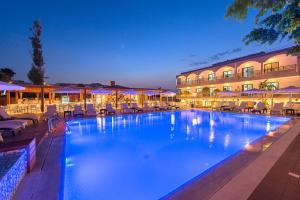 a large swimming pool with chairs and a hotel at Sunny Days Hotel in Ixia