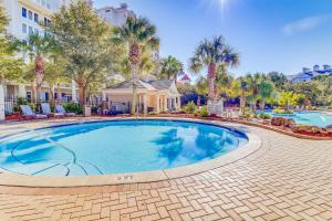 a swimming pool at a resort with palm trees at Lasata 3204 in Destin