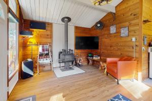 uma sala de estar com uma parede com painéis de madeira e um fogão em Riverbend Hideaway em Baring