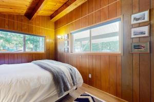 um quarto com painéis de madeira e uma cama com uma janela em Riverbend Hideaway em Baring