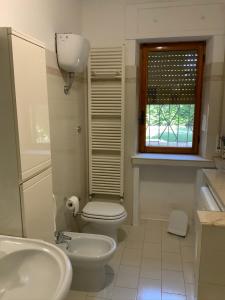 bagno con servizi igienici, lavandino e finestra di AL MANDORLO Casa Vacanze a Viterbo