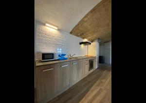una cocina con armarios de madera y una pared de ladrillo en Costa Maresme, Barcelona, Clarks 3 Bdr TownHouse, en Vilassar de Dalt