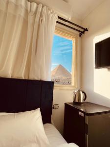 开罗Yamour Pyramids View的一间卧室设有窗户,享有金字塔的景色