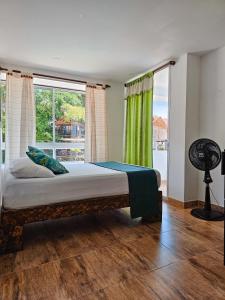sypialnia z łóżkiem i dużym oknem w obiekcie Hosteria La Medusa w mieście Cocorná
