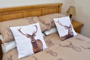 a bed with two pillows with a deer on it at Beachcombers in Pollachar