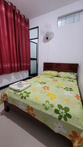 Un dormitorio con una cama verde con flores. en Hospedaje Vista Paraíso, en Tingo María