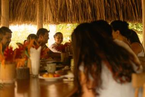 eine Gruppe von Menschen, die an einem Tisch in einem Restaurant sitzen in der Unterkunft Playa Bonita Hotel EcoCabañas Tayrona in Buritaca