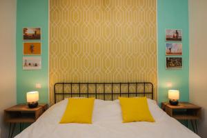 a bedroom with a bed with two yellow pillows at Mill Central Apartment in Sibiu