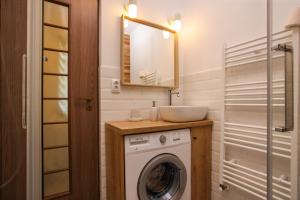 a bathroom with a washing machine and a sink at Mill Central Apartment in Sibiu