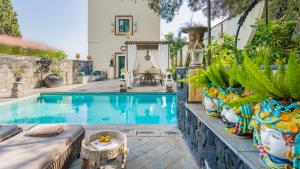 ein Pool im Hinterhof mit Pflanzen in der Unterkunft Villa Urbis Taormina, luxury villa in the heart of Taormina with swimming pool & lift in Taormina