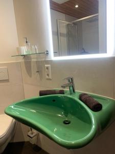 ein grünes Waschbecken im Bad mit WC in der Unterkunft Ferienwohnung am Franziskaner Tor in Überlingen