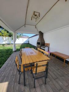 una mesa de madera y sillas bajo una tienda en Qafqaz Panoramic Mountain Chalet, en Gabala