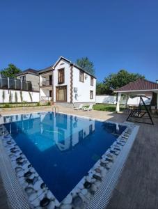 a swimming pool in front of a house at Qafqaz Panoramic Mountain Chalet in Gabala