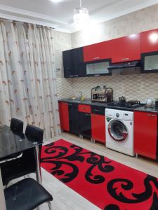 a kitchen with red cabinets and a washing machine at Qafqaz Milan Villa With Outdoor Heated Pool in Gabala