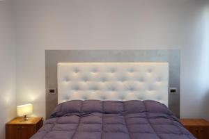 a bedroom with a purple bed with a large headboard at Casa sotto le stelle in Turin
