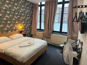 sypialnia z łóżkiem i ścianą z kwiatami w obiekcie BED Collège w mieście Namur